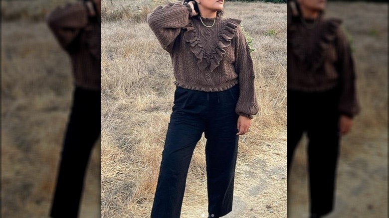 Woman brown ruffled sweater black pants