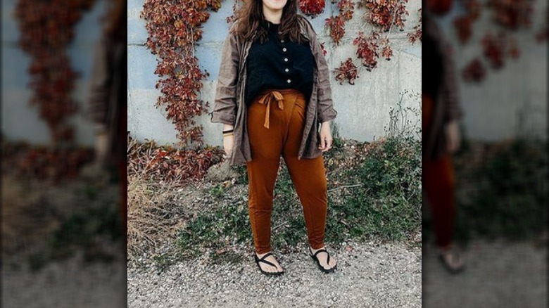 Woman rust colored pants black shirt