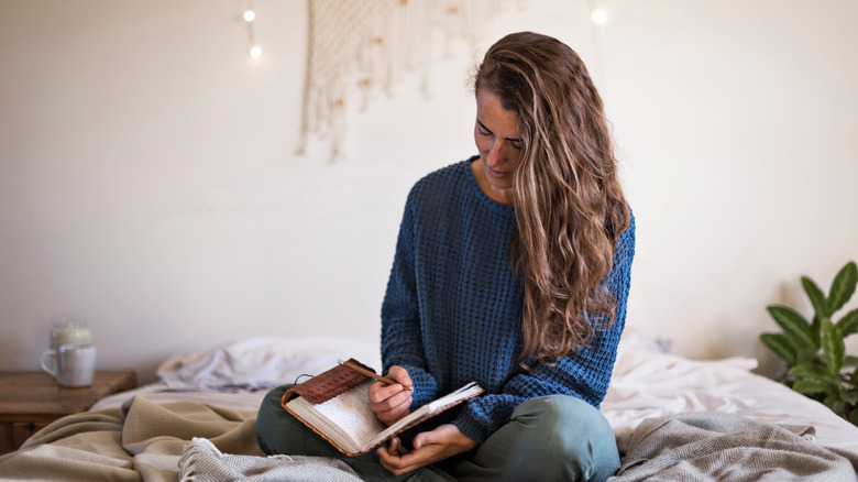 Woman journaling in bedroom