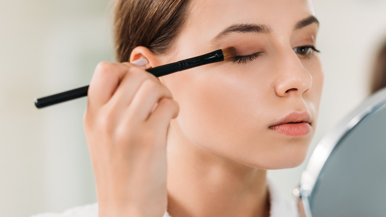 Woman applying brown eyeshadow