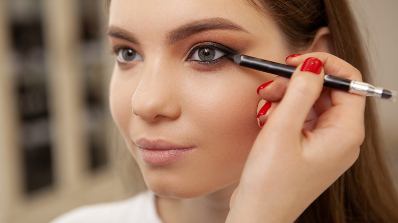 Woman applying black eyeliner