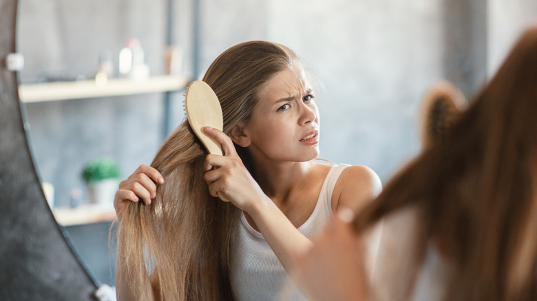 Woman teasing hair in mirror