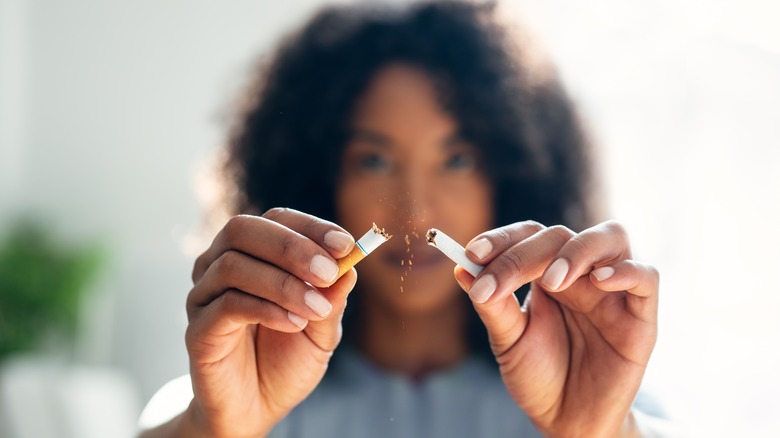 Brunette-haired woman breaking cigarette