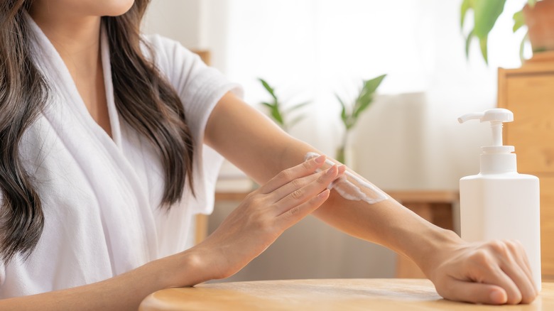 Woman using body lotion