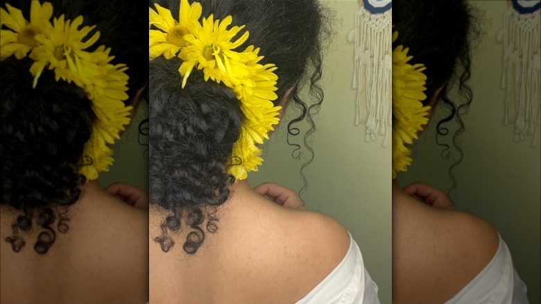 woman wearing yellow flowers in curly bu 