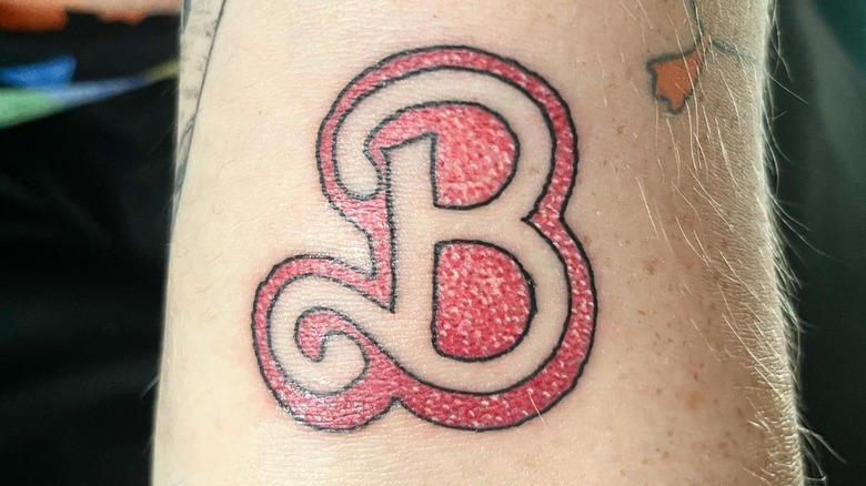 arm with glittery letter b tattoo