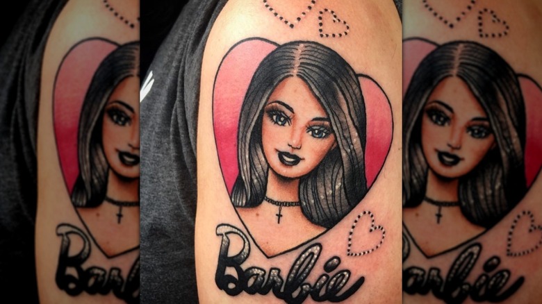 arm with goth barbie tattoo
