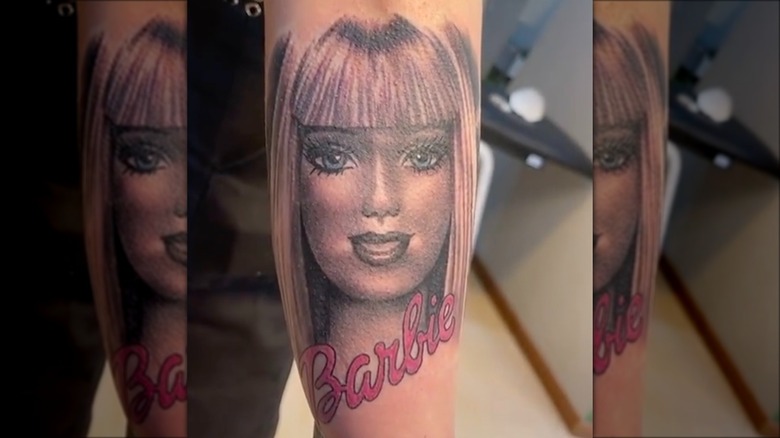 arm with greyscale barbie tattoo