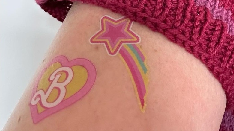 arm with barbie press on tattoos
