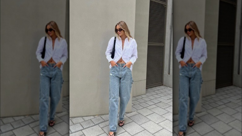 A woman wearing baggy jeans with a white button-up