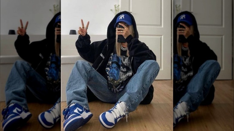 A woman wearing baggy jeans with a graphic tee and hoodie