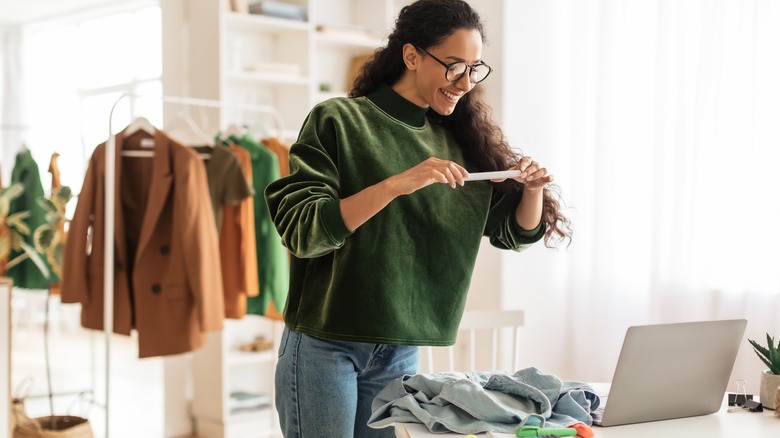 woman taking picture of garments