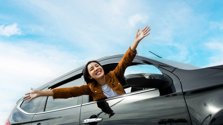 woman leaning out of car smiling