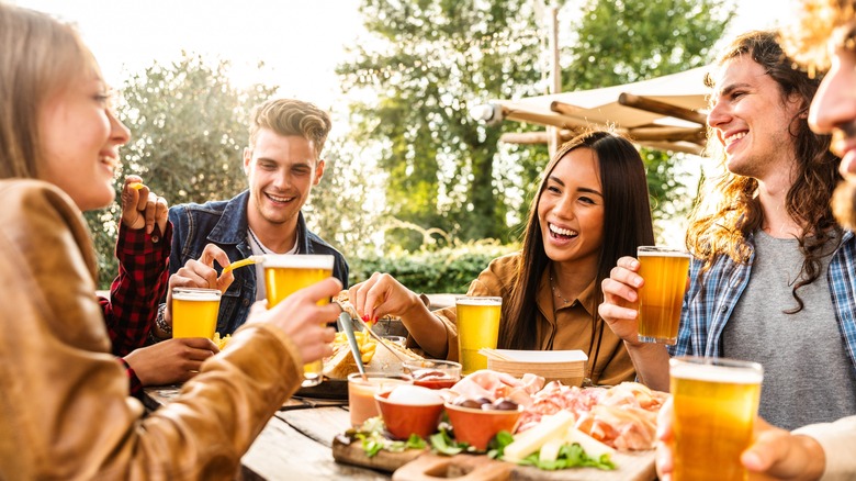 friends drinking beer and eating charcuterie