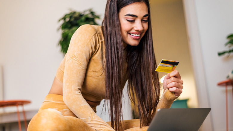 woman smiling with credit card and laptop