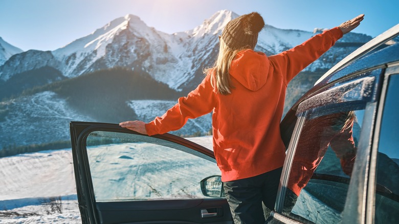 woman standing outside of car in snow