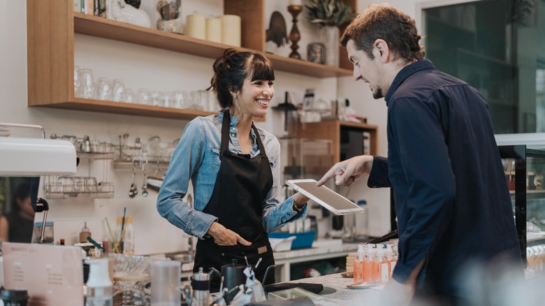 woman working register at coffee shop