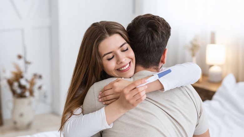 happy couple with pregnancy test