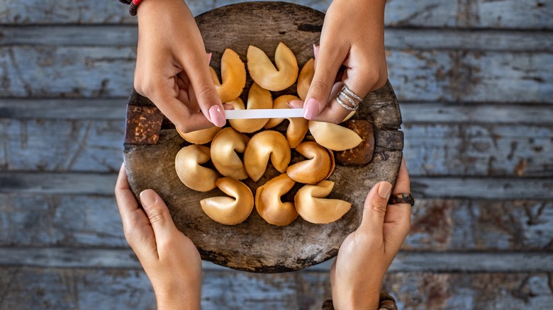 female hands holding fortune cookies