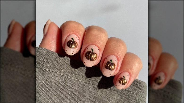 Nude manicure with small golden charms