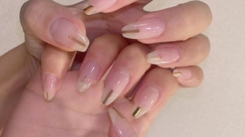 Nude manicure with a central gold stripe