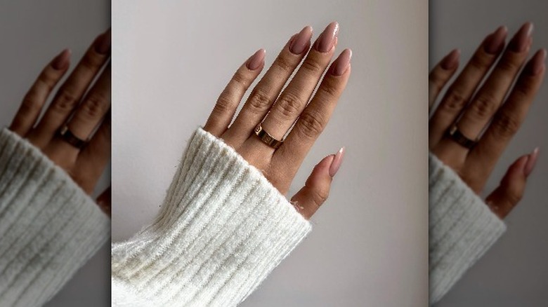 Hand showing long nude nails