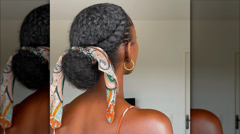 Low bun chignon style with silk hair scarf