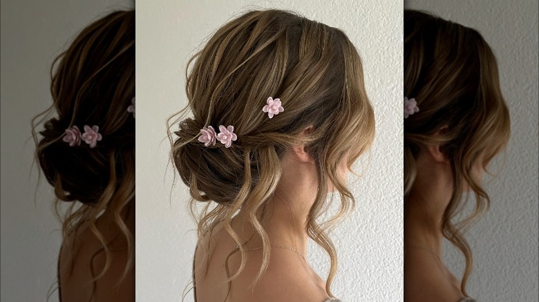 Low chignon style with pink flower pins