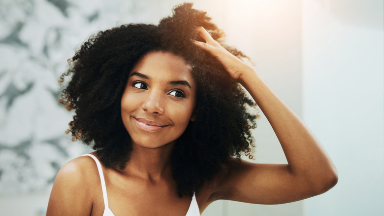 Smiling woman scrunching curly hair