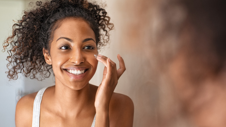 Woman applying face cream 