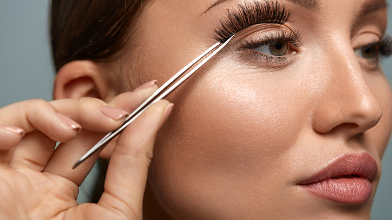 Woman applying fake eyelashes