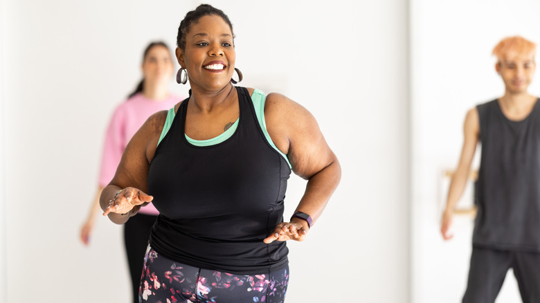 A woman enjoying herself in dance class.