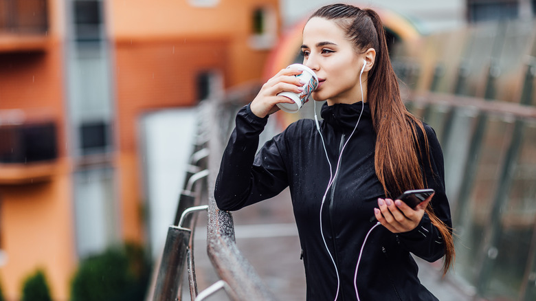 Woman having coffee while jogging