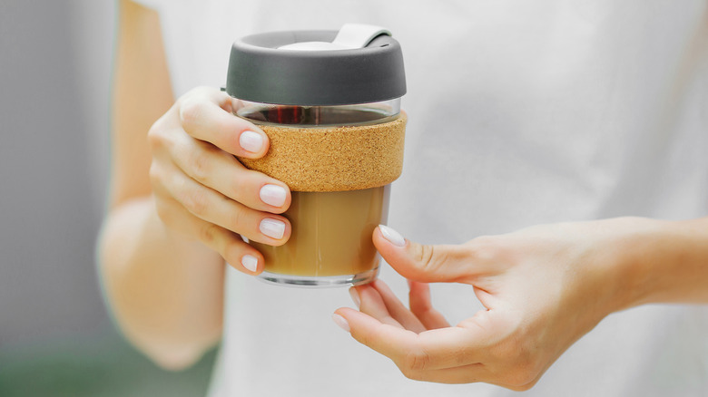 Woman holding coffee travel mug