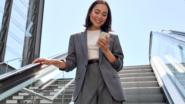 Woman texting as she walks down the stairs