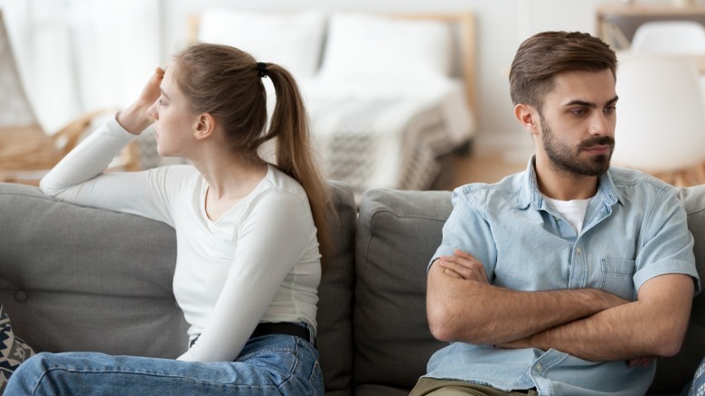 Woman and man looking away from each other on couch