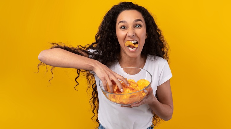 Woman aggressively munching on chips