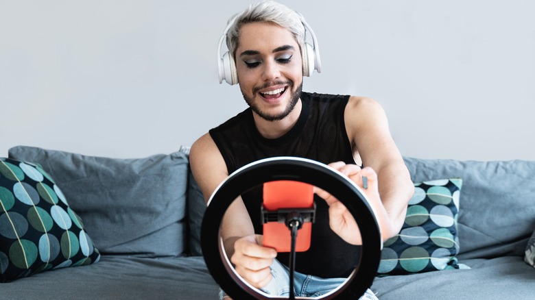 A man setting up his phone on a ring light