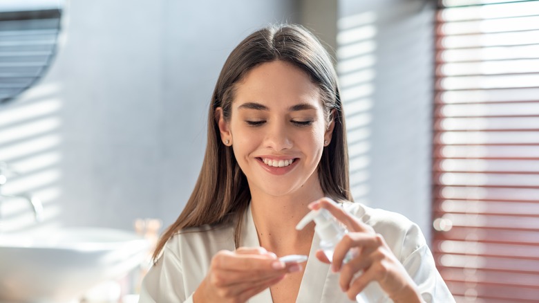 woman holding oil and cotton pad