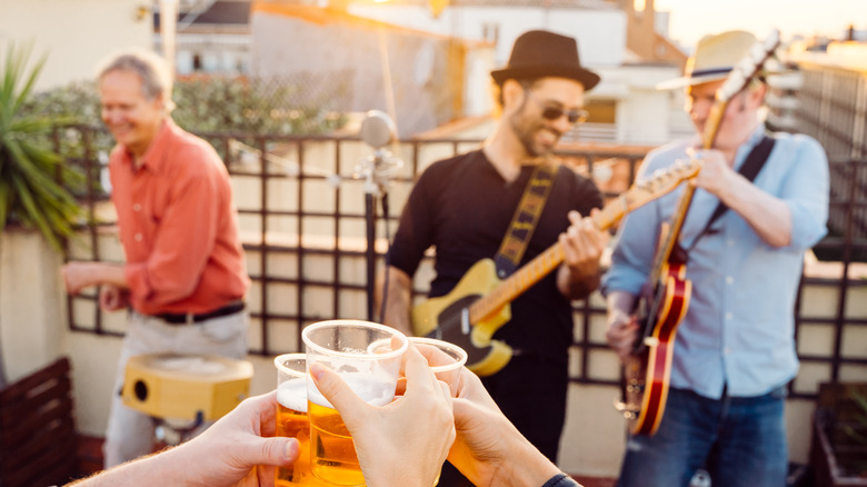 people raising a beer/ band playing