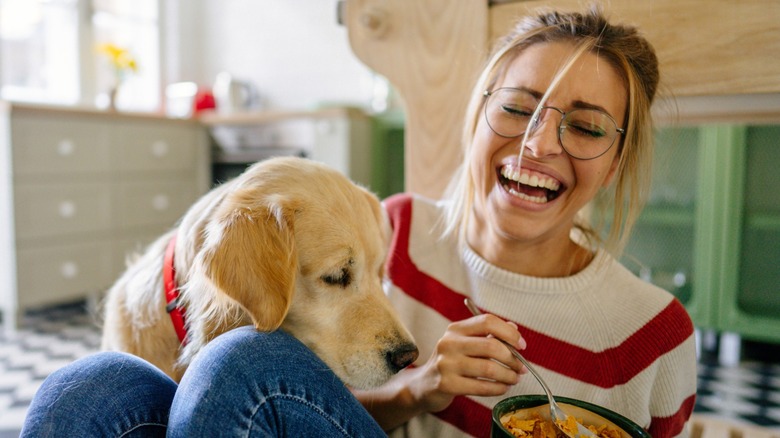 woman laughing with a dog