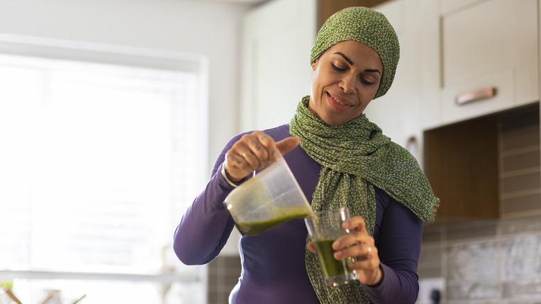 Woman pouring drink into glass