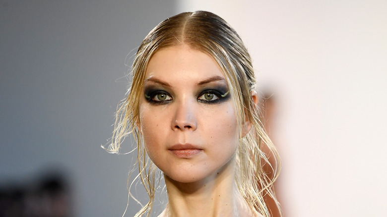 A model with heavy black eye makeup on the runway