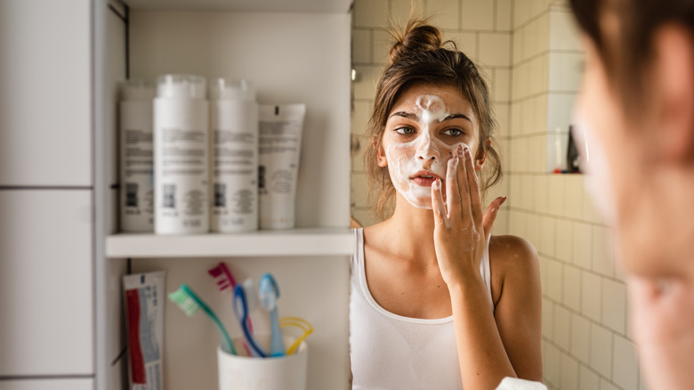 Woman washing face with cleanser