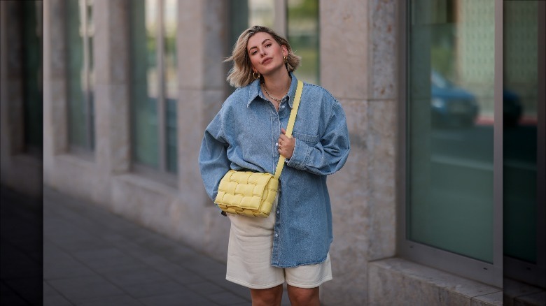 Woman wearing a Bottega crossbody bag.