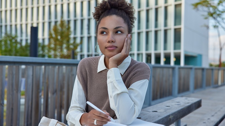 woman thinking while journaling