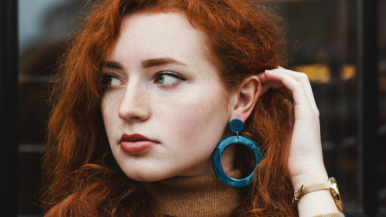 woman wearing plastic blue earring 