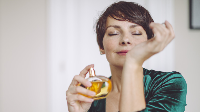 Woman spraying perfume