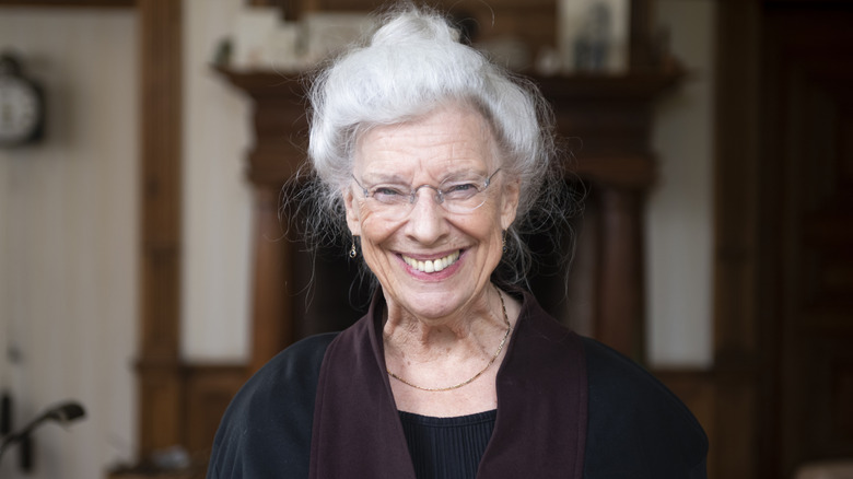 Older woman with white hair wearing a bun.