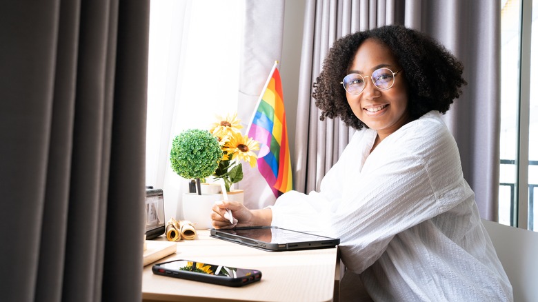 Person sitting at desk with miniature Pride flag